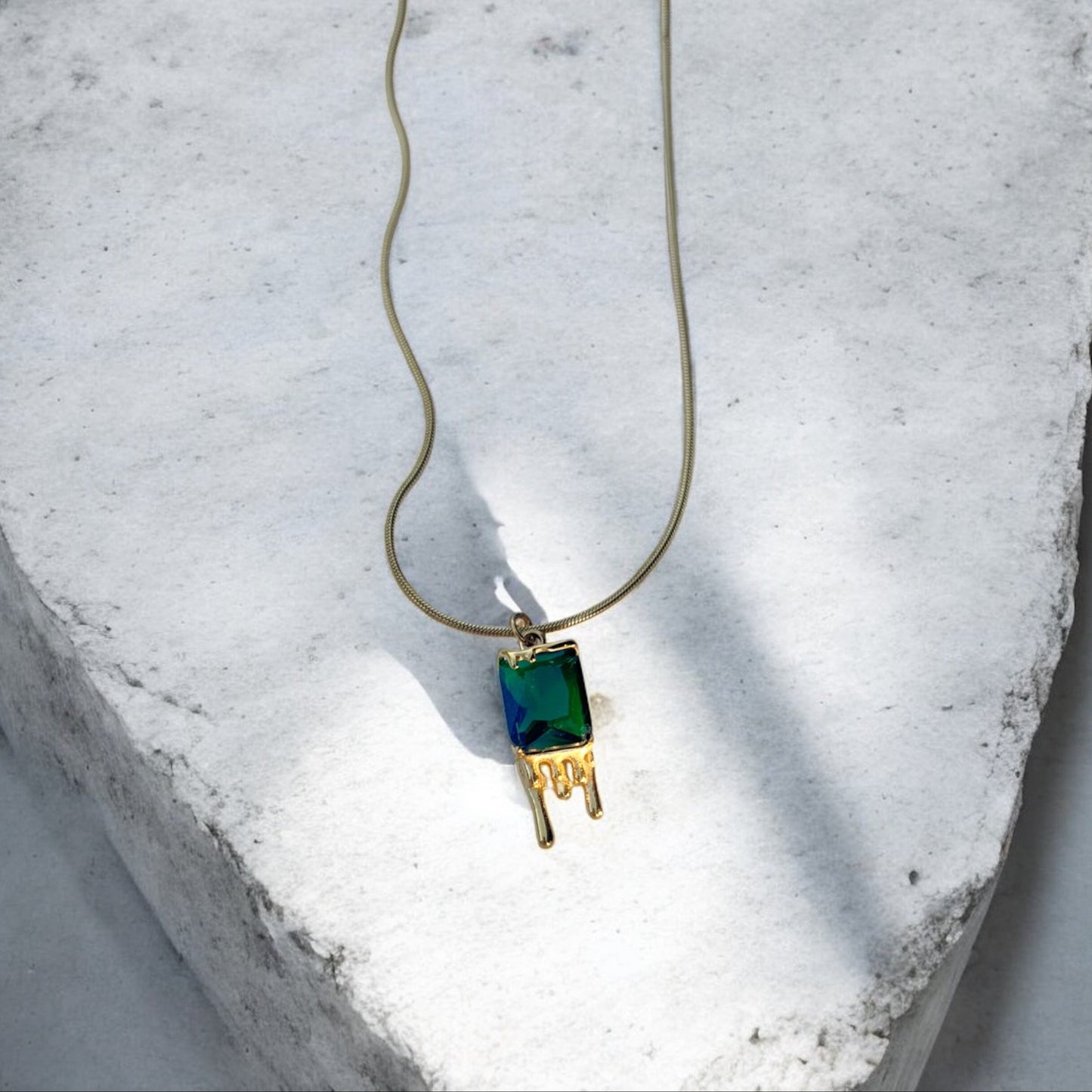 Necklace with a green pendant on a textured white surface